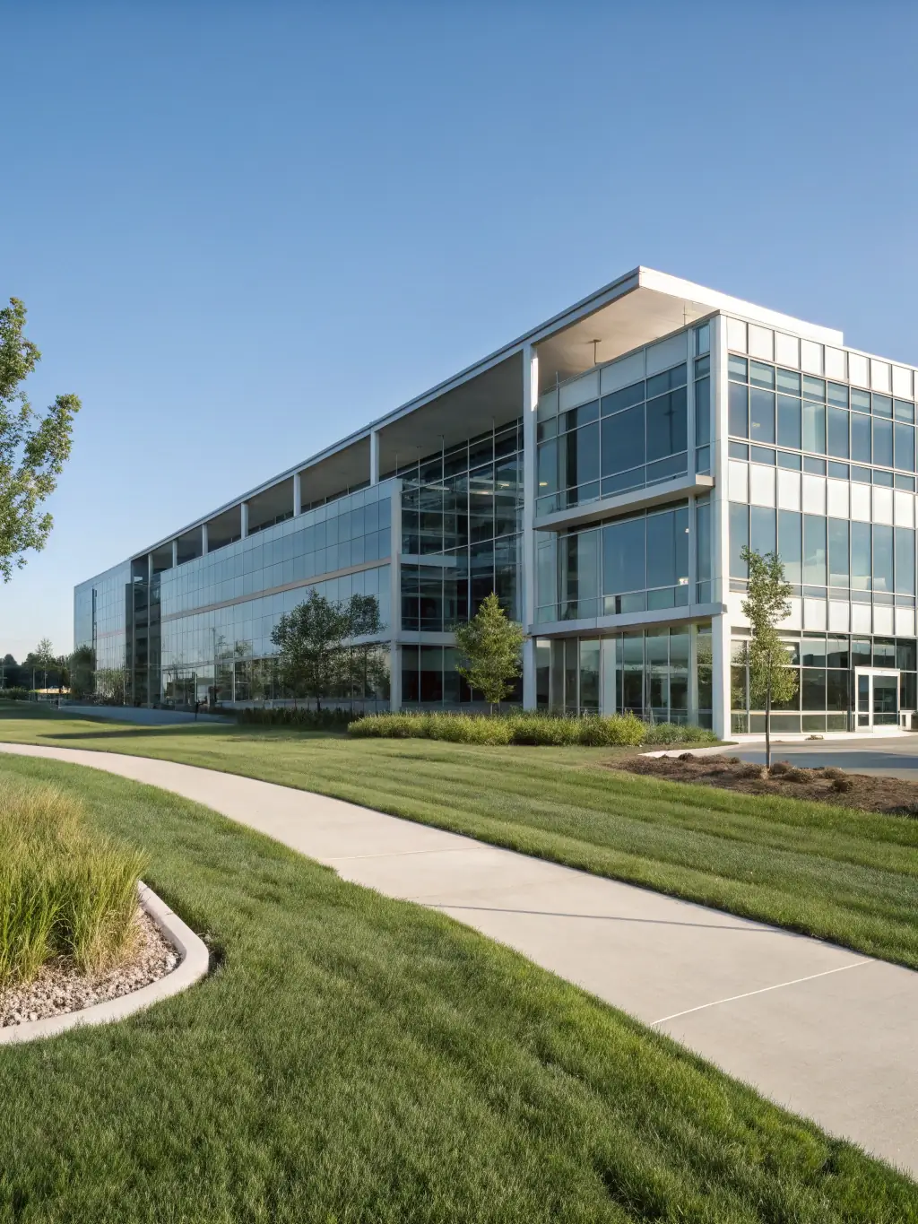 A modern office building with glass facade during daytime, showcasing available office spaces for lease at PrimeEstate.