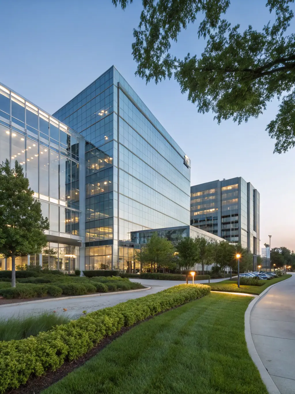A modern office building exterior during a sunny day, showcasing its glass facade and professional landscaping, symbolizing a prime investment opportunity in commercial office spaces.