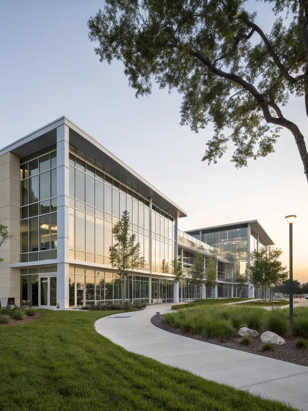 A modern office building exterior during a sunny day, showcasing its architectural design and landscaping, representing property selection services.