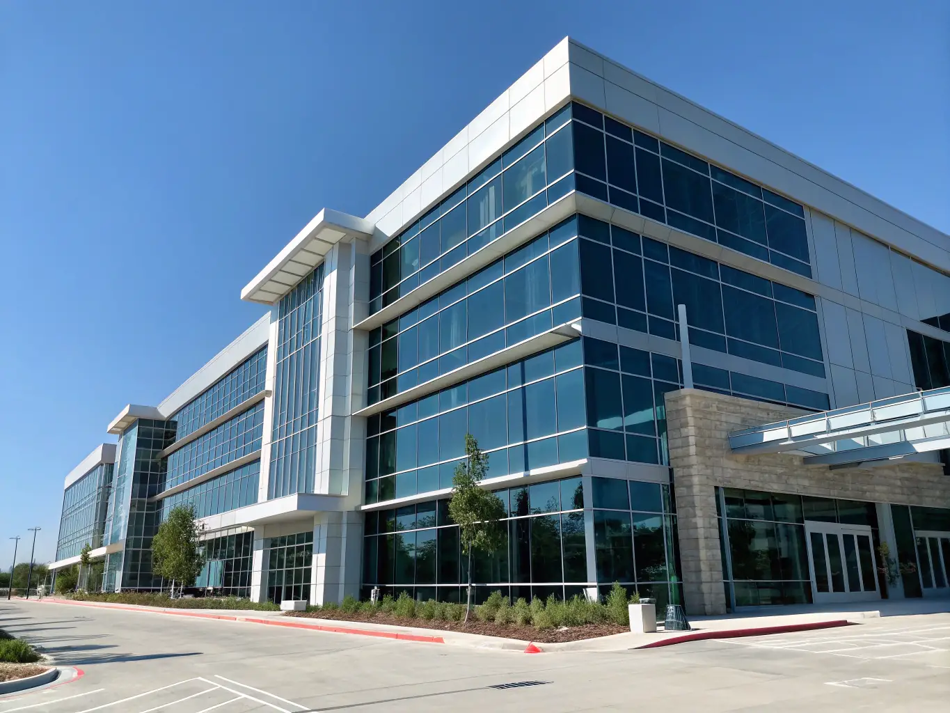 A modern office building with glass facade, reflecting the sky, symbolizing property selection and acquisition services.